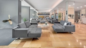 A spacious lobby with modern grey sofas, a coffee table, and a decorative fan. - B&B Hotels Park Hotel Suisse Santa Margherita Ligure (Santa Margherita Ligure)