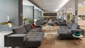 A modern lounge area with grey sofas, a central coffee table, and a decorative fan. - B&B Hotels Park Hotel Suisse Santa Margherita Ligure (Santa Margherita Ligure)