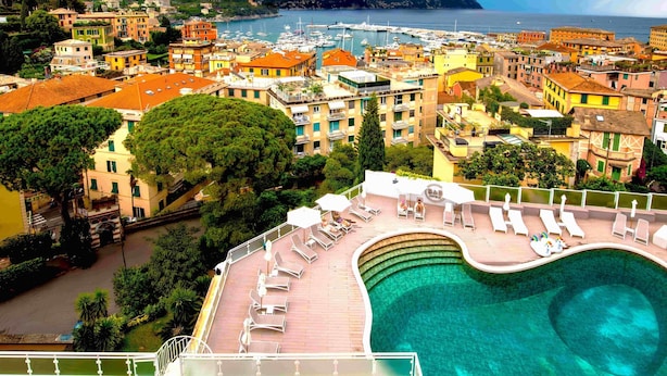 A coastal town with a marina, colorful buildings, and a large swimming pool with sun loungers. - B&B Hotels Park Hotel Suisse Santa Margherita Ligure (Santa Margherita Ligure)