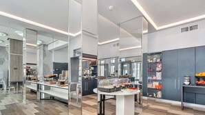 A modern kitchen with a central island, mirrored walls, and a variety of food items displayed. - B&B Hotels Park Hotel Suisse Santa Margherita Ligure (Santa Margherita Ligure)