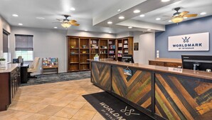 A reception area with a wooden reception desk, a sign for 'Worldmark by Wyndham', and a ceiling fan. - WorldMark Lake of the Ozarks (Osage Beach)