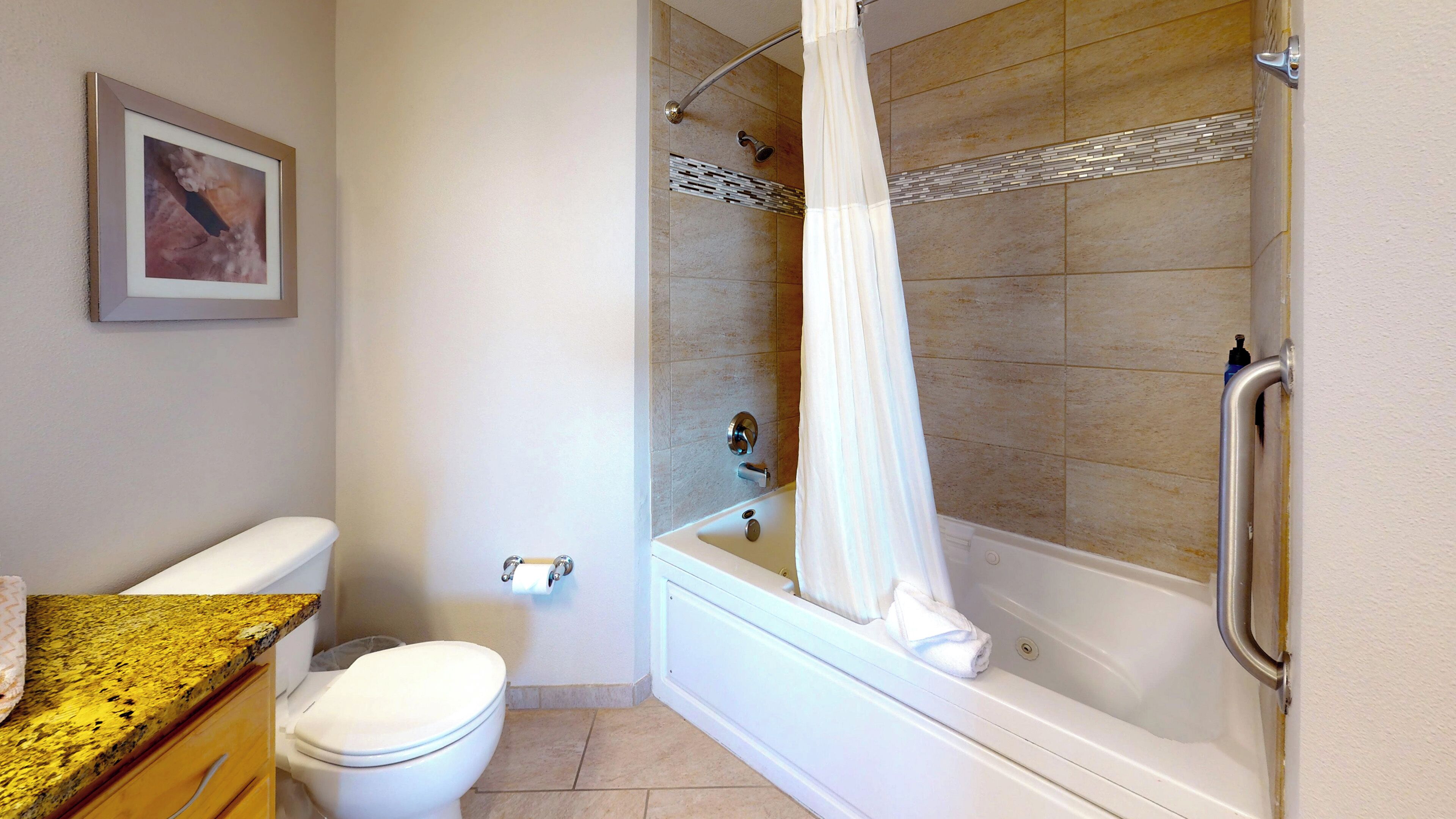 A bathroom with a toilet, sink, and bathtub with a shower curtain.