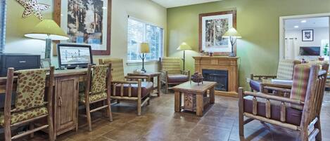 A spacious living room with wooden furniture, a fireplace, and large windows.