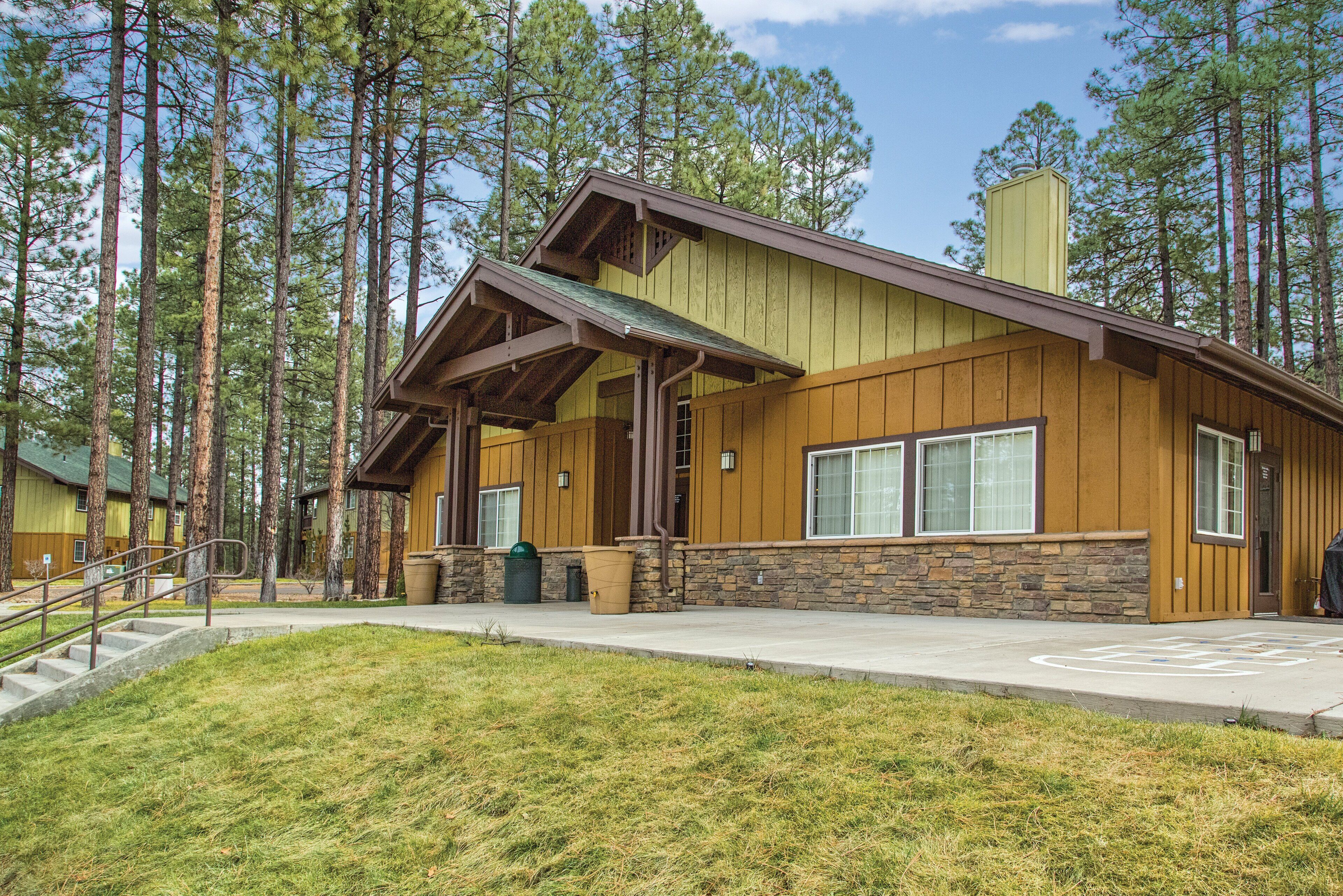 A lodge with a stone foundation, wooden exterior, and a covered porch.