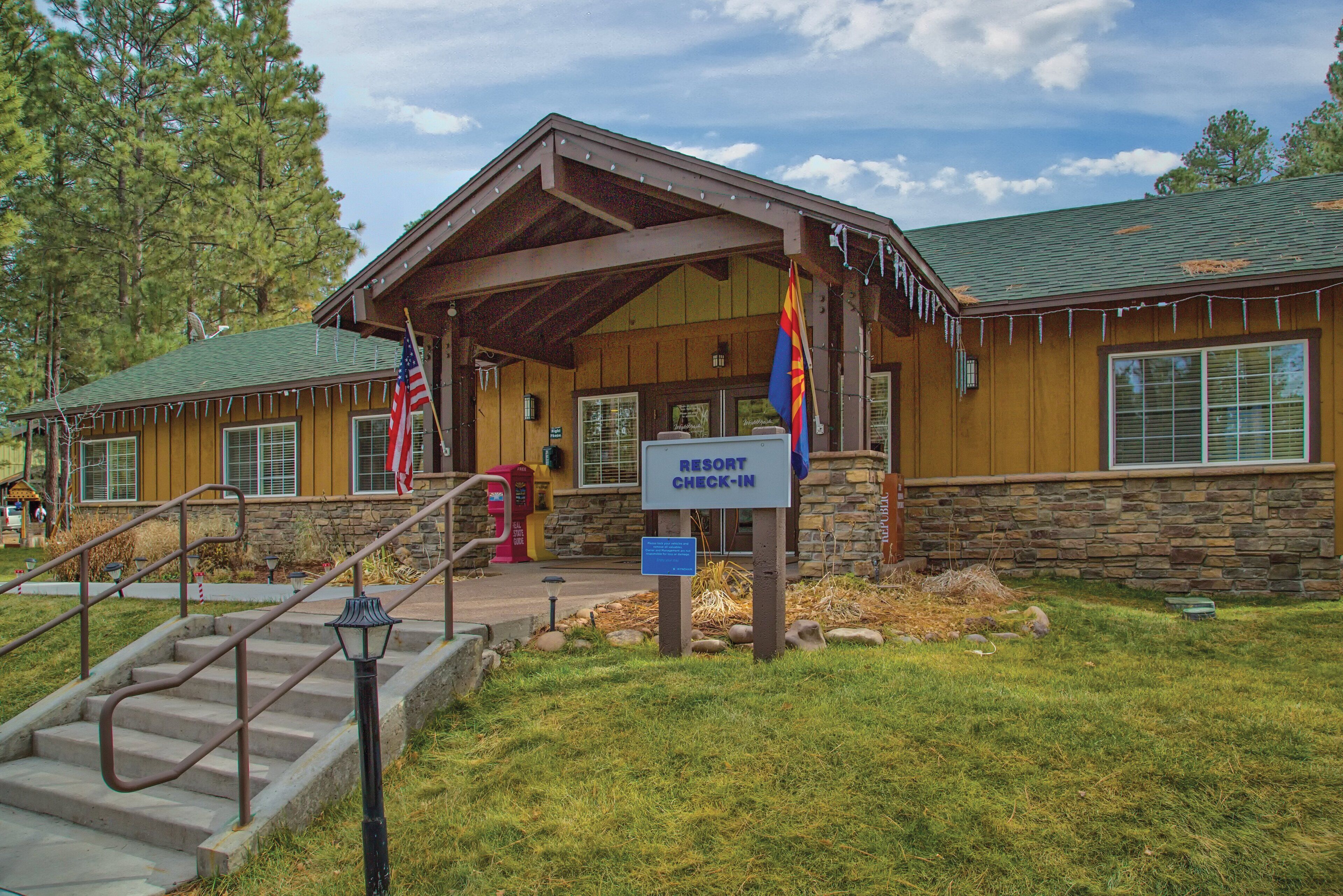 A resort check-in building with a stone facade, a covered entrance, and a sign indicating the check-in area.