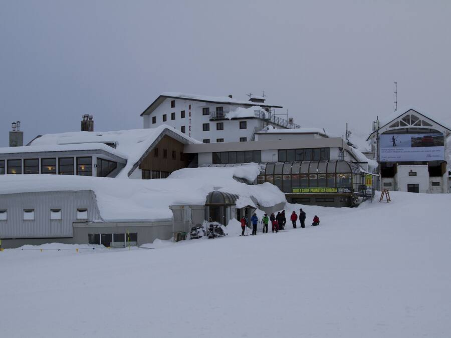 A snow-covered building with multiple windows and a ski lift.