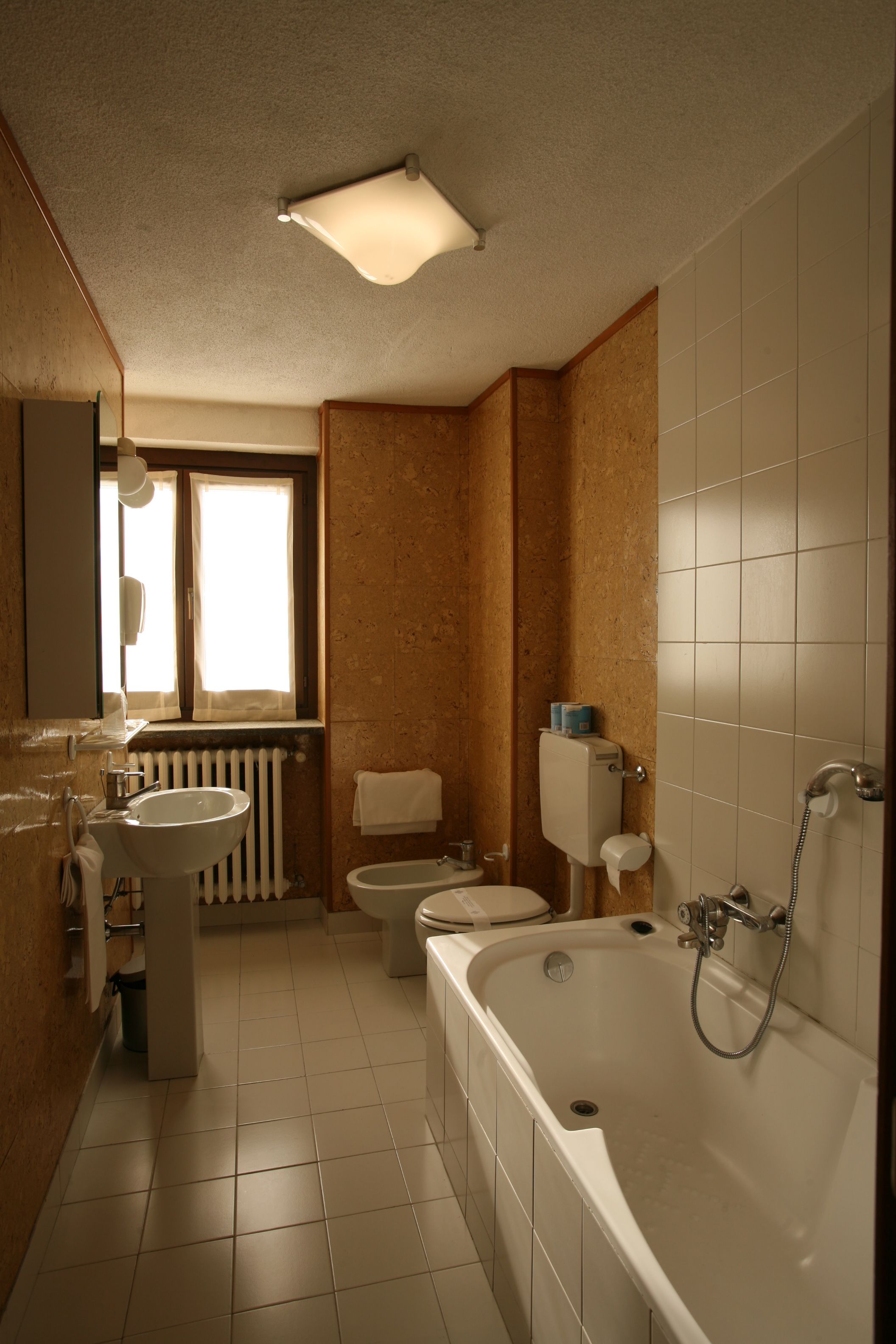 Un baño con bañera, inodoro, lavabo y ventana.