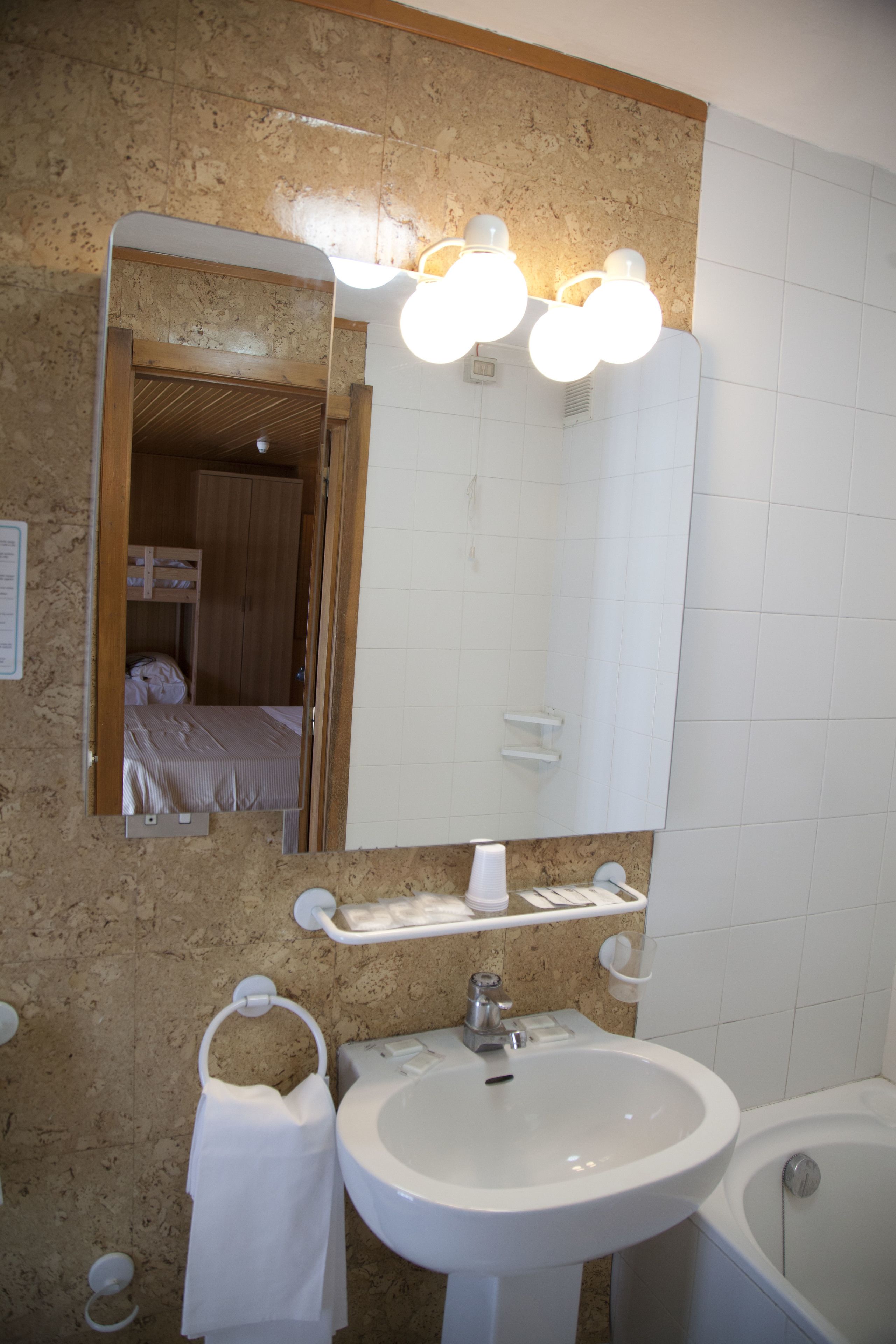 Un bagno con lavandino, specchio e vasca da bagno.