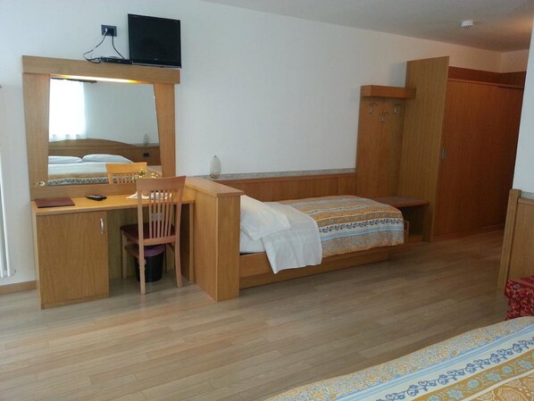 A compact room with a wooden desk, chair, and bunk bed.