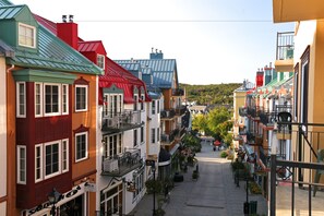 A narrow street lined with colorful buildings, balconies, and outdoor seating areas.