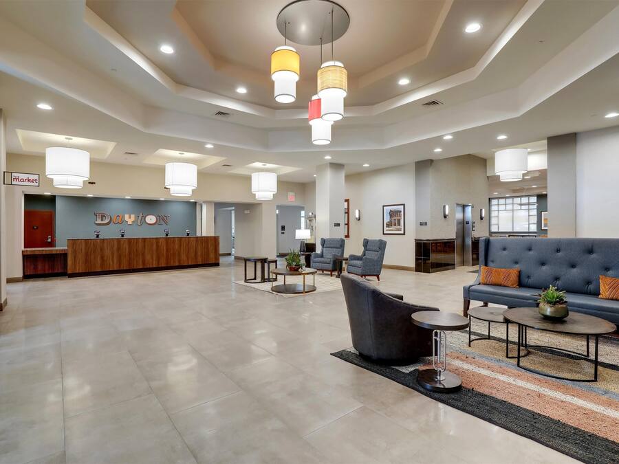 A spacious lobby with a reception desk, seating area, and modern lighting fixtures.