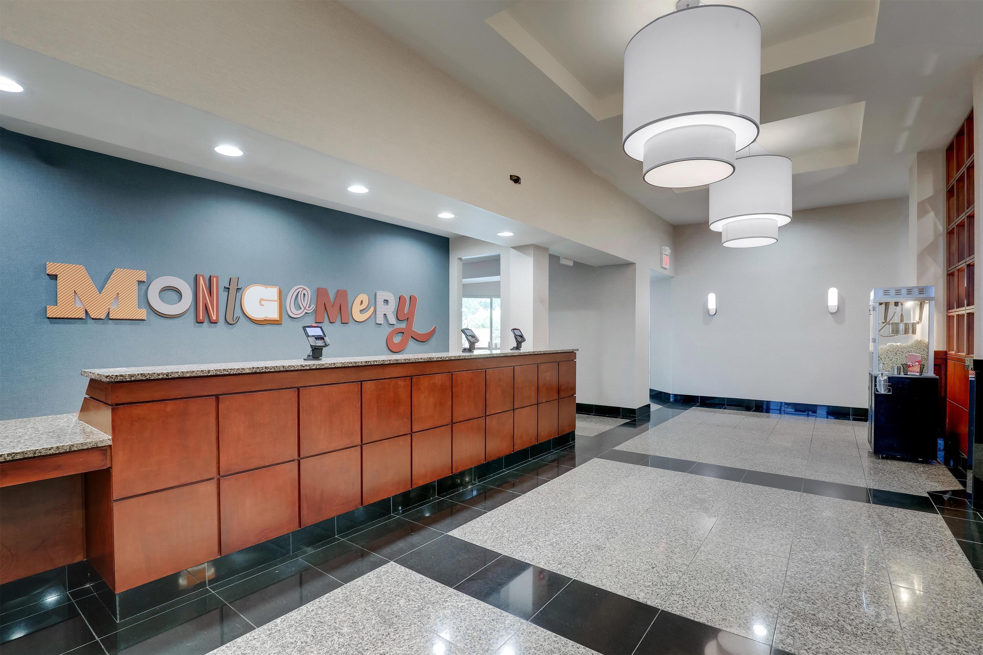 A reception area with a wooden counter, a blue wall with the name 'Montgomery' in large letters, and a tiled floor.