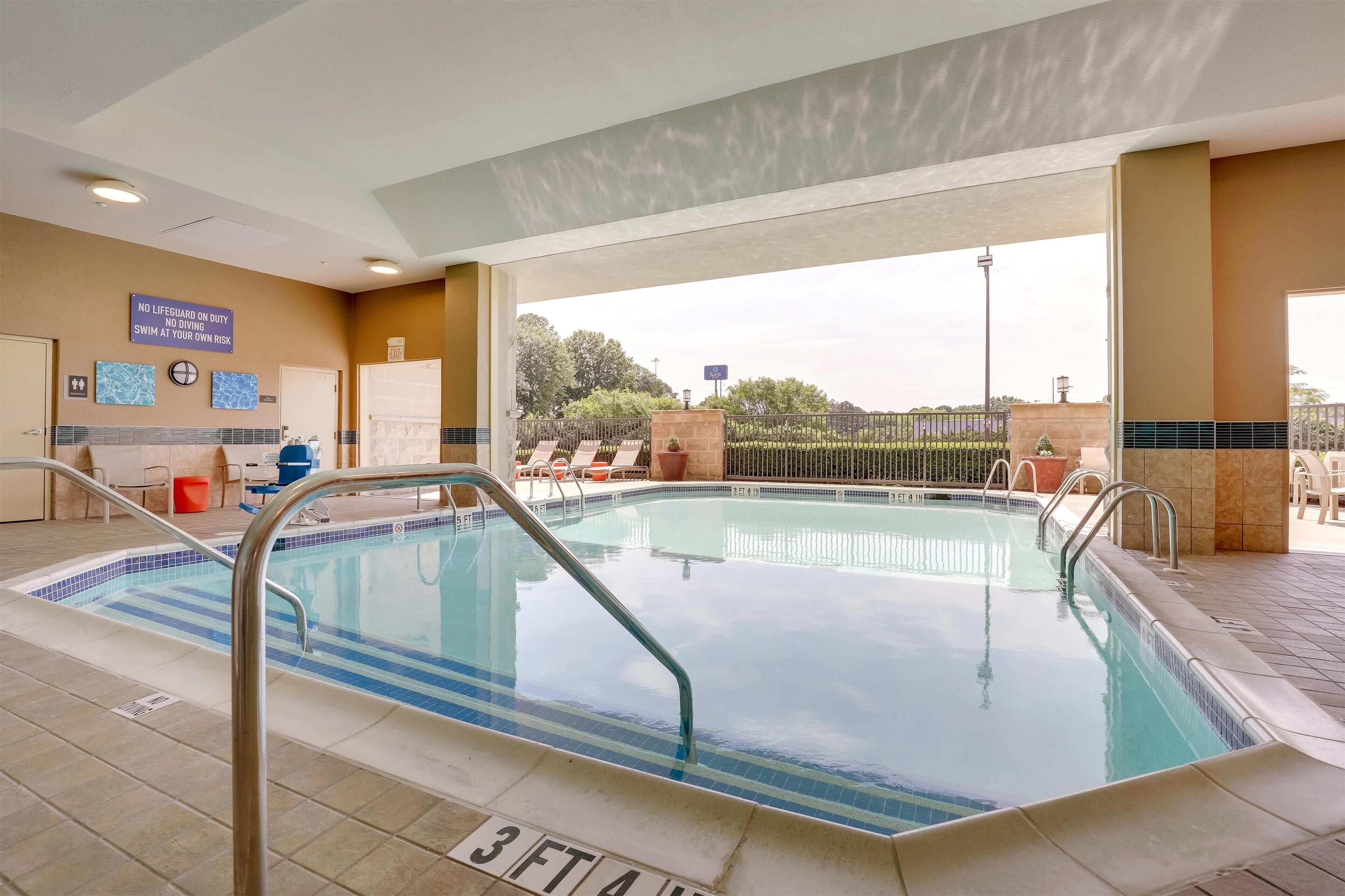 A hotel pool area with a sign indicating no lifeguard on duty.