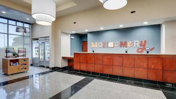 A reception area with a counter, a wooden cabinet, and a large window.