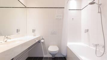 Un baño moderno con lavamanos, inodoro y bañera blancos.