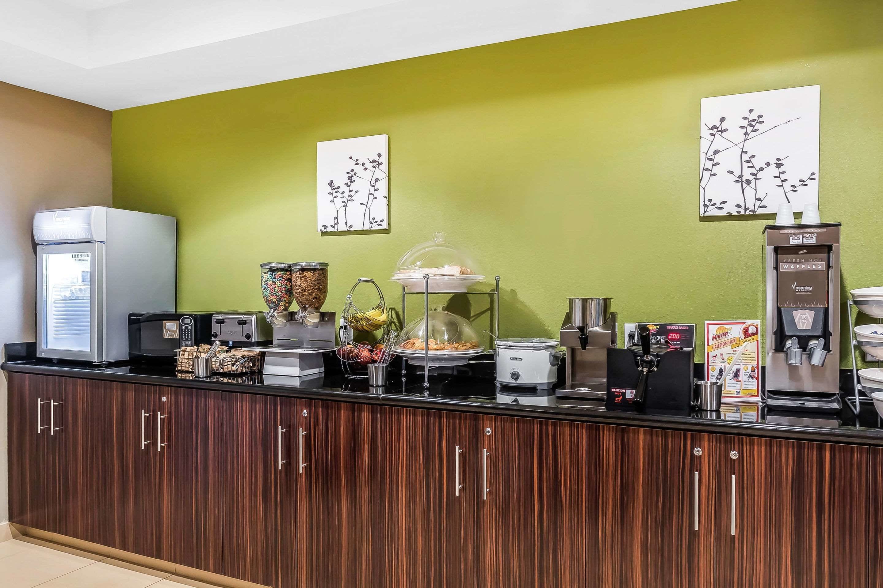 Eine Frühstückstheke mit Kühlschrank, Kaffeemaschine und verschiedenen Lebensmitteln.