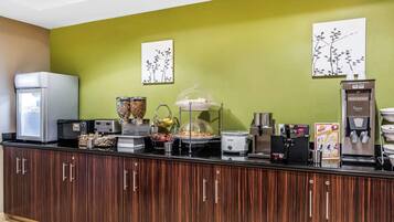 Eine Frühstückstheke mit Kühlschrank, Kaffeemaschine und verschiedenen Lebensmitteln.