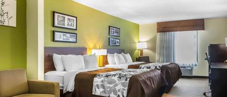 Habitación de hotel con dos camas, un sofá y un escritorio.