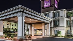L’entrée d’un hôtel, avec une enseigne bien visible indiquant qu’il s’agit d’un hôtel Sleep Inn & Suites.