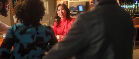 A bar setting with patrons seated around tables.