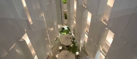A multi-level atrium with open spaces, seating areas, and greenery.