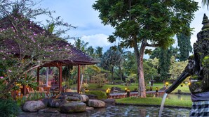 A serene garden with a pond, rocks, a gazebo, and a statue. - Tanah Gajah, a Resort by Hadiprana (Ubud)