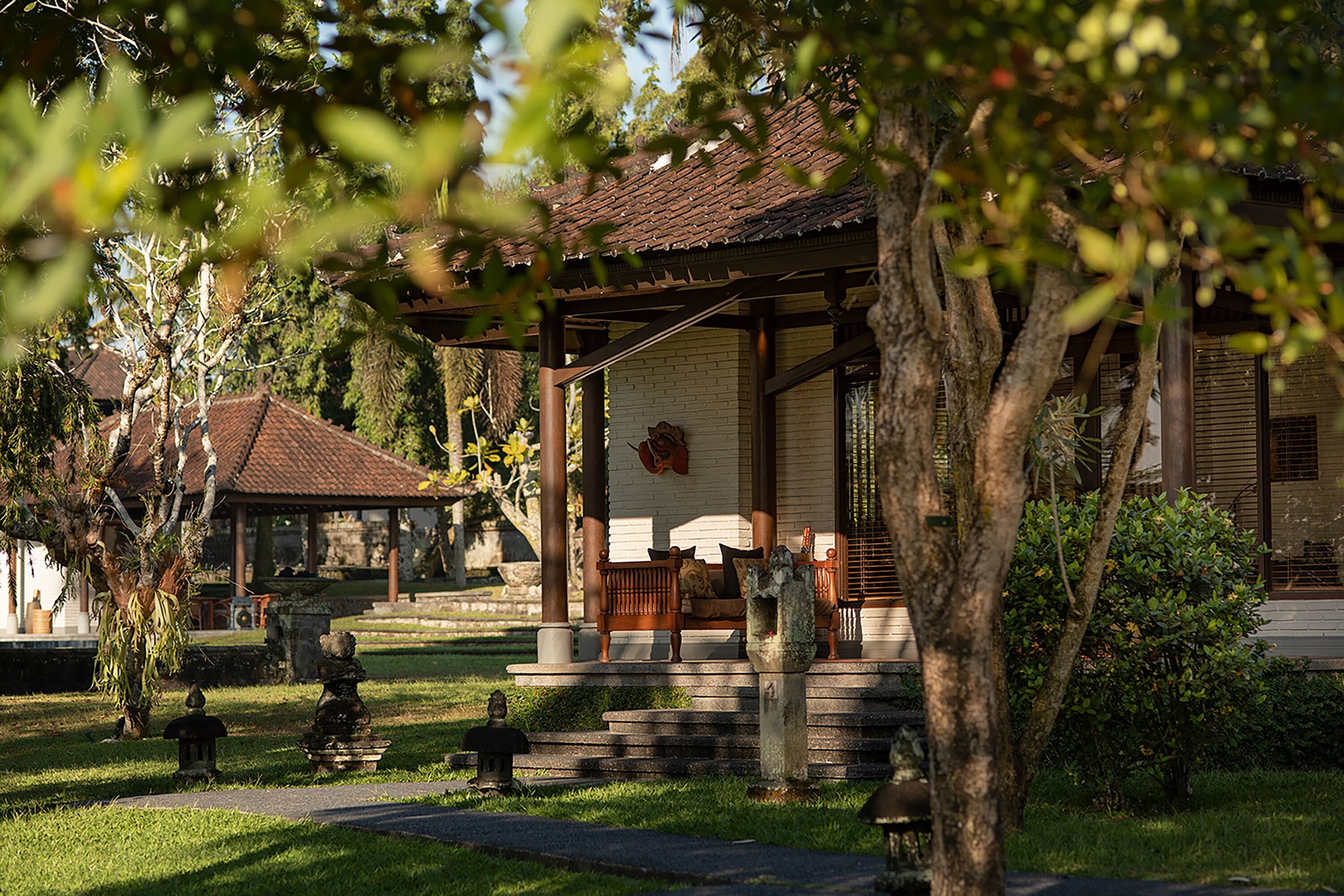 A traditional building with a tiled roof, a wooden porch, and a stone pathway leading to it.