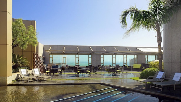 A pool area with lounge chairs and a seating area with a view of the ocean. - Four Points by Sheraton Le Verdun (Beirut)