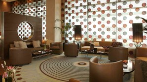 A modern lobby with a circular mirror, sofas, armchairs, and a patterned carpet. - Four Points by Sheraton Le Verdun (Beirut)