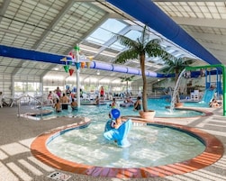 Una piscina techada, una piscina al aire libre de temporada, sombrillas