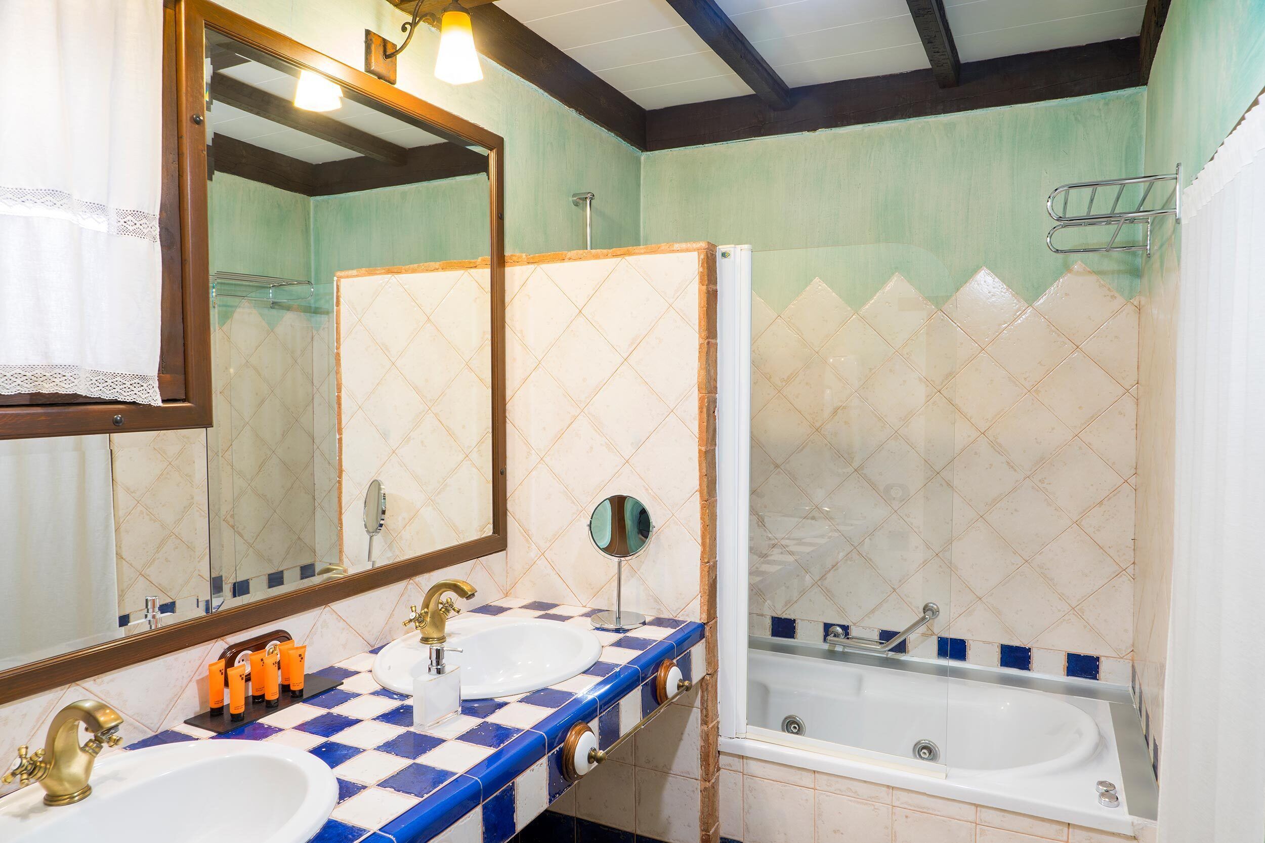 Une salle de bain avec deux lavabos, une baignoire et un miroir.