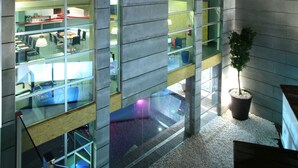 A modern building with multiple floors, large windows, and a glass atrium.