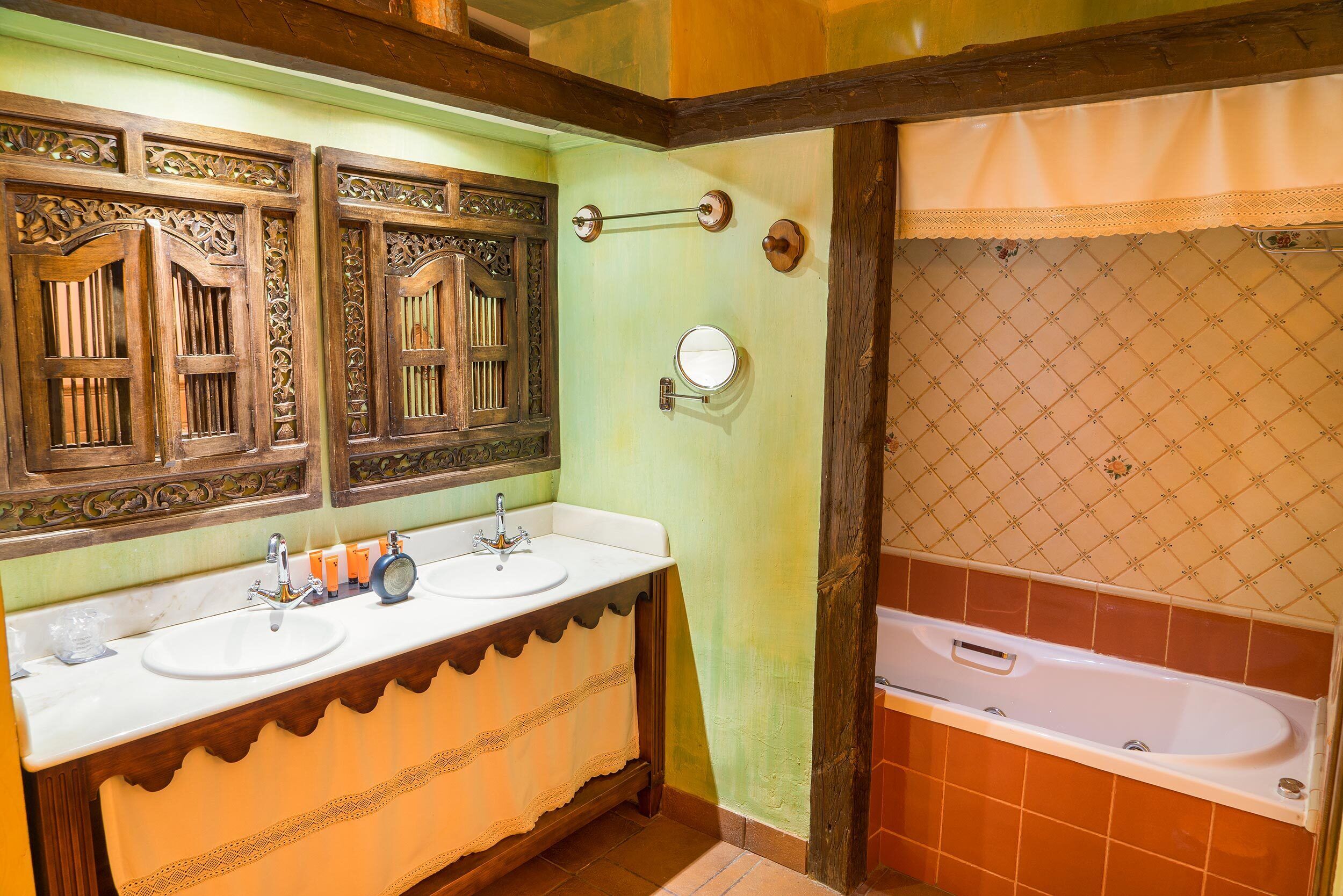 Un baño con dos lavamanos, un espejo y una bañera.