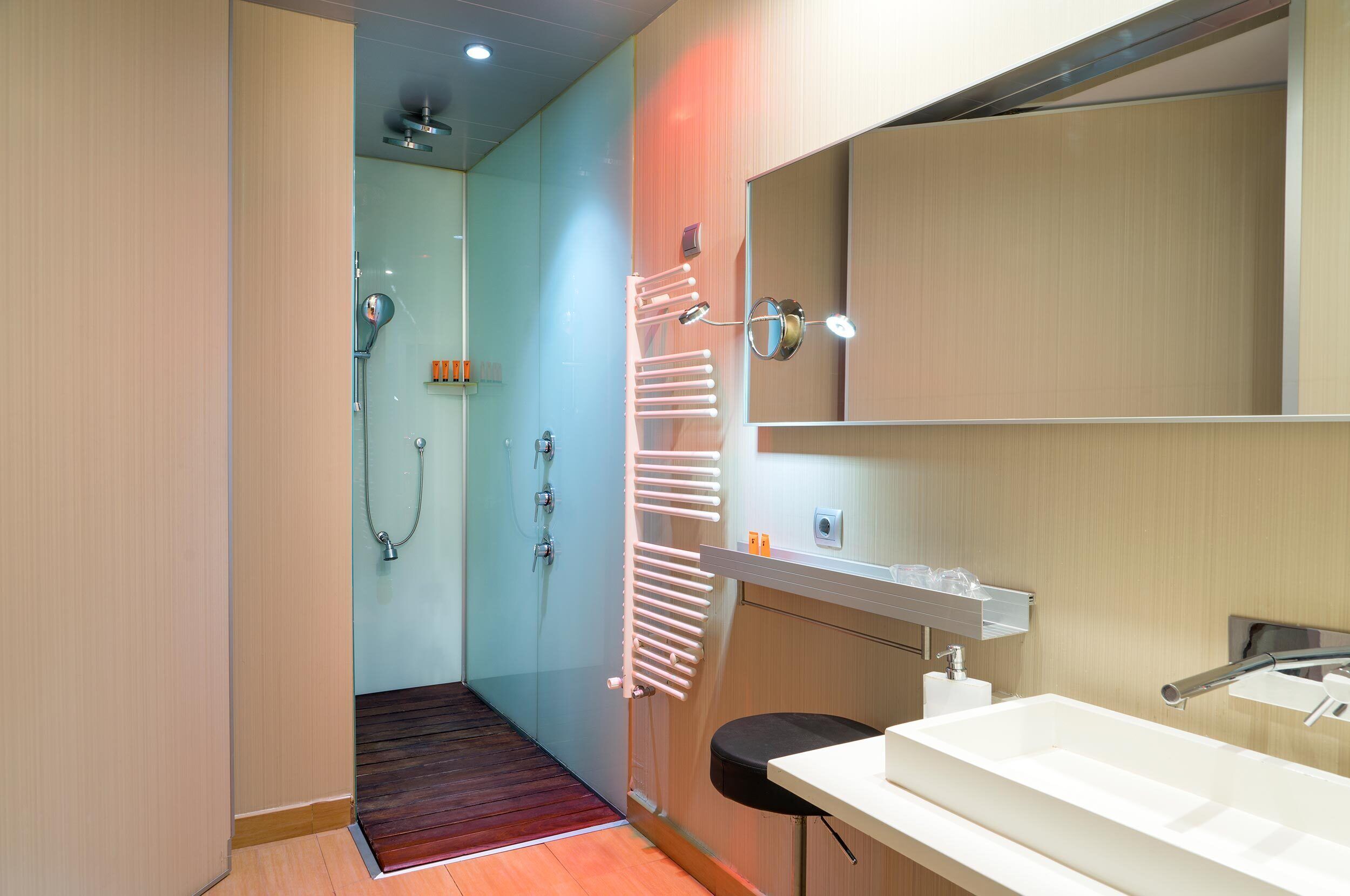 A modern bathroom with a shower, a toilet, and a sink.