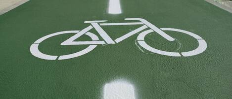 A green bike lane with white bicycle symbols.