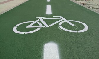 A green bike lane with white bicycle symbols.