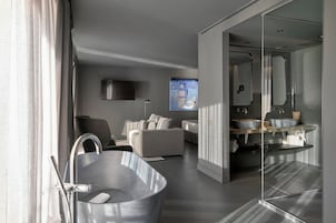 Une salle de bain moderne avec une baignoire sur pieds, un grand miroir et un meuble-lavabo élégant.
