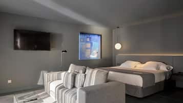 A modern bedroom with a bed, a sofa, a TV, and a painting on the wall.