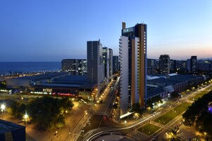 A cityscape at dusk with prominent high-rise buildings, including a tall building labeled "PRINCESS."
