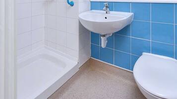 Une salle de bain avec une douche, un lavabo et des toilettes.