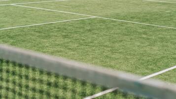 Primer plano de un campo deportivo verde con líneas blancas delimitadoras.
