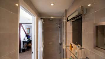 A modern bathroom with a glass shower enclosure, a white sink, and a mirror above it.