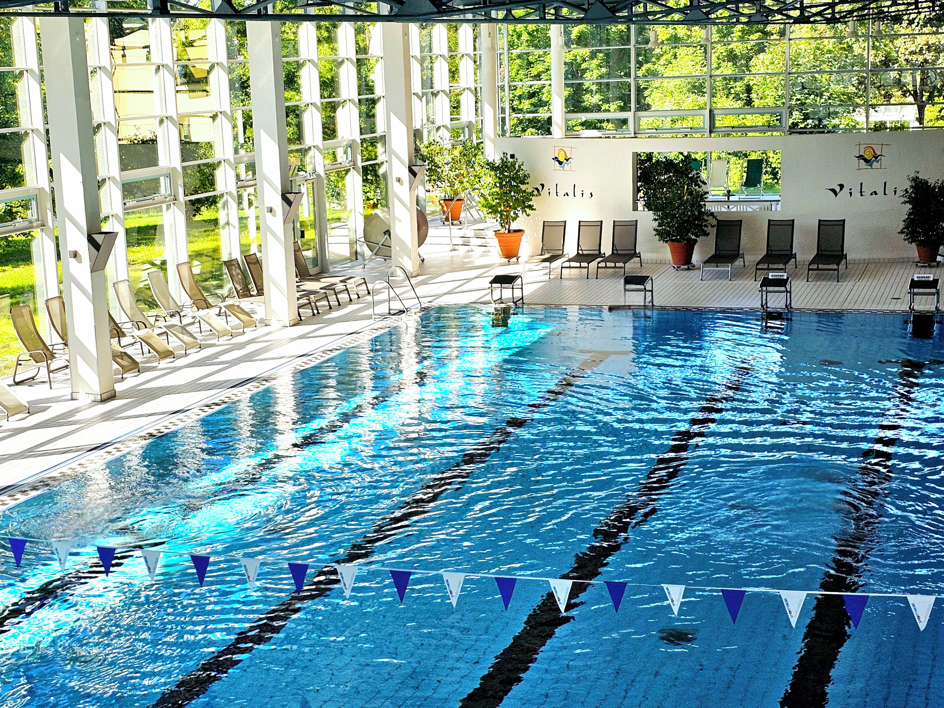 Una piscina con carriles delimitados y sillas de descanso.