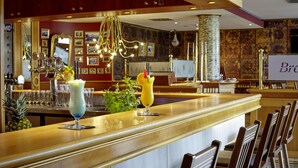 Una zona de bar con dos bebidas en la barra, una piña y un letrero que dice "Brava".
