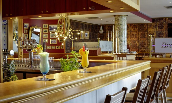 A bar area with two drinks on the counter, a pineapple, and a sign that reads "Brava". - Parkhotel Weiskirchen (Weiskirchen)