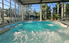 An indoor swimming pool with clear water, surrounded by large windows and a covered roof. - Parkhotel Weiskirchen (Weiskirchen)