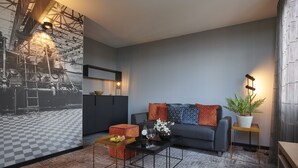 A modern living room with a grey sofa, a black coffee table, and a checkered floor. - Parkhotel Weiskirchen (Weiskirchen)