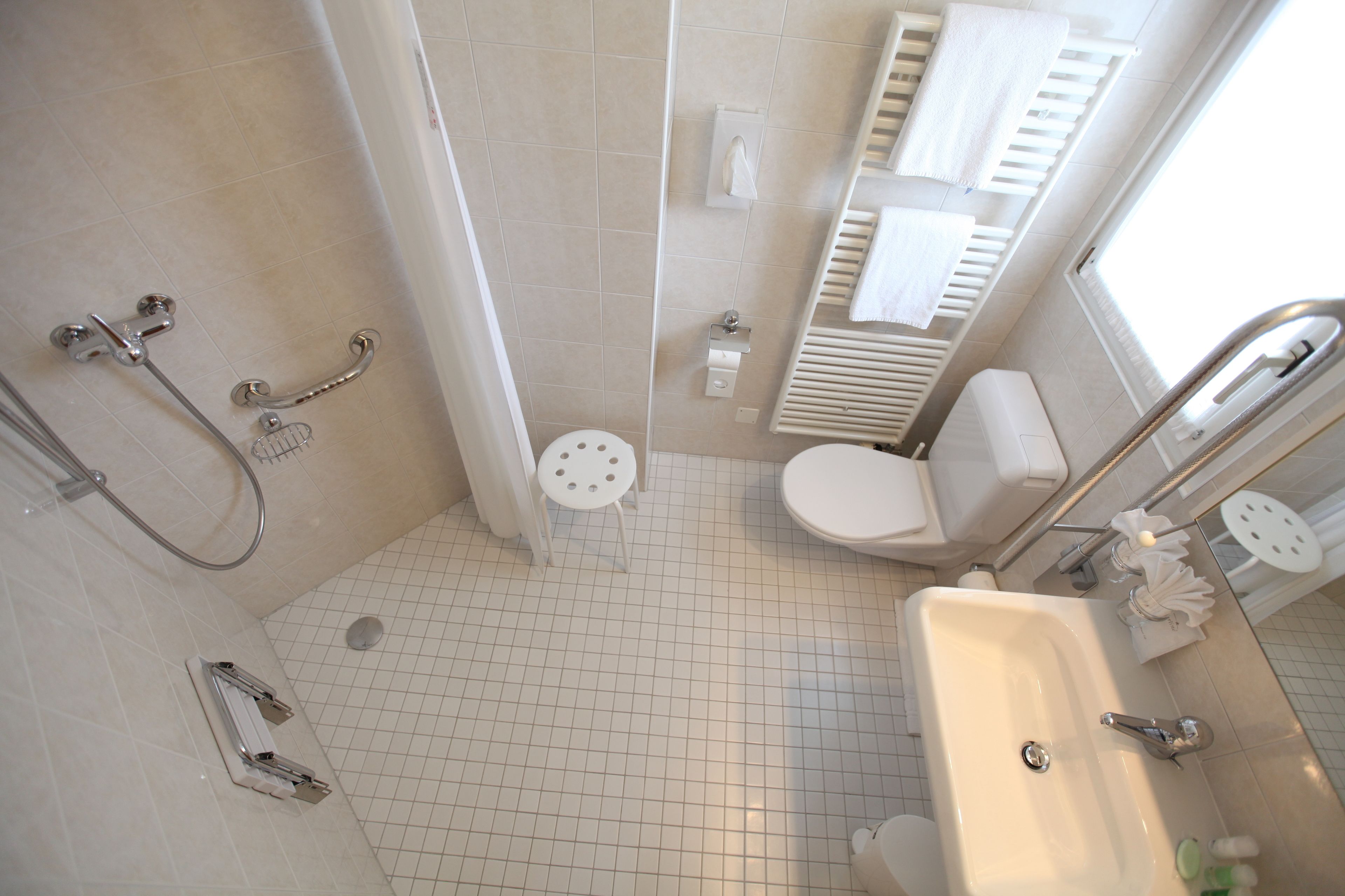 Ein Badezimmer mit Dusche, Toilette, Waschbecken und Handtuchhalter.