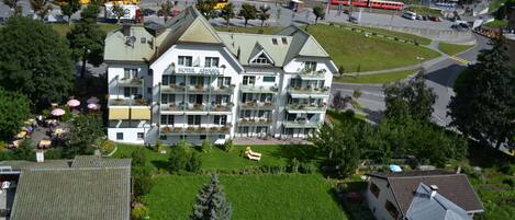 A hotel with a central courtyard, multiple balconies, and a view of the surrounding town.