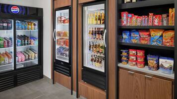 Un espace équipé de distributeurs automatiques proposant des produits Pepsi, des chips Doritos et d’autres en-cas.